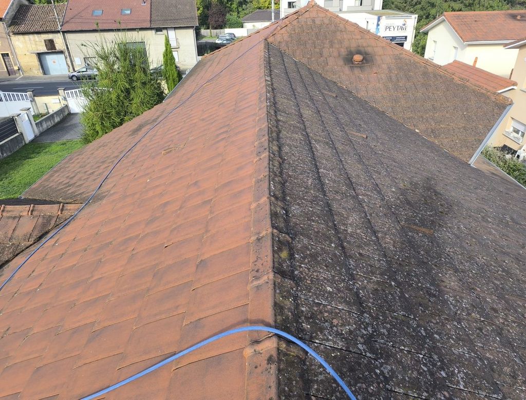 Toiture en tuiles pendant un démoussage : un pan nettoyé, l'autre encore couvert de mousses