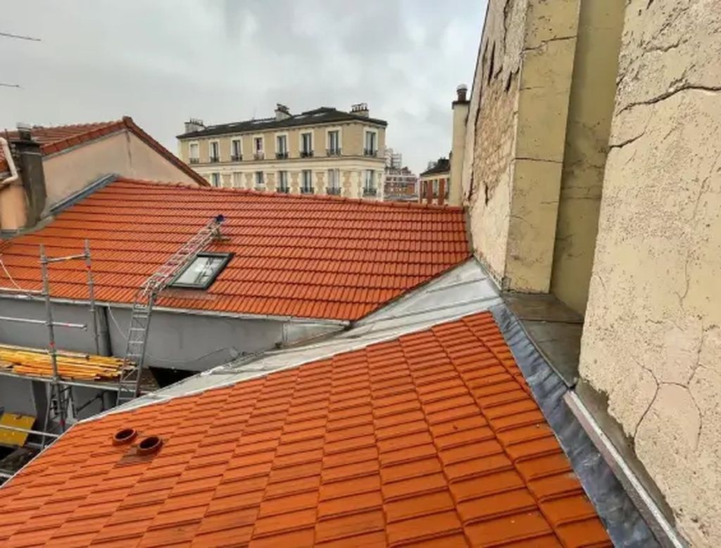 Toiture en tuiles neuves avec échafaudage et fenêtre de toit